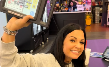 A winning lottery ticket with symbols and several $100 bills fanned out next to it.